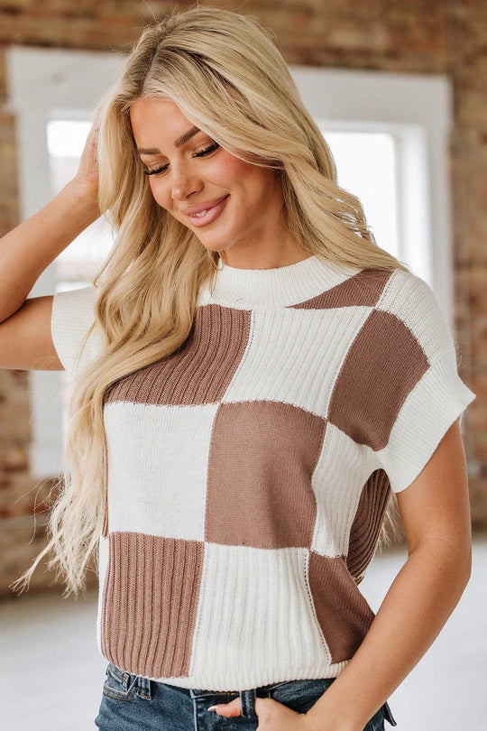 Woman wearing a checkered sweater with a neutral background