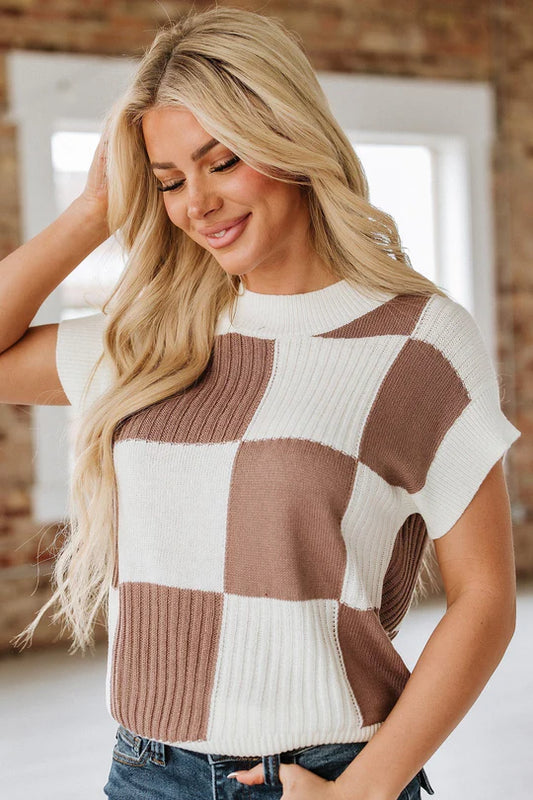 Woman wearing a checkered sweater with a neutral background